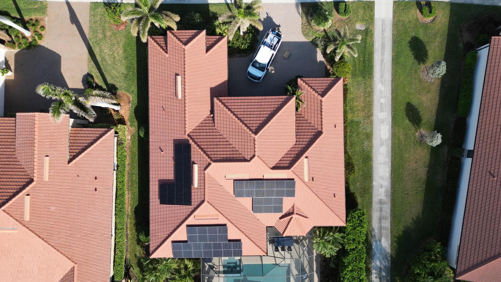 Top-down aerial of solar panels on terracotta tile roof in Southwest FL